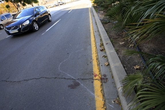 Restos de sangre de la víctima en la calzada señalados con una raya blanca que trazó un policía local. :: manuel molines