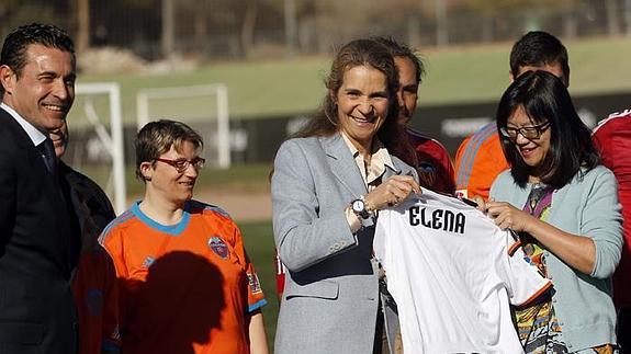 La infanta Elena recibe una camiseta del Valencia con su nombre de manos de Lay Hoon. 
