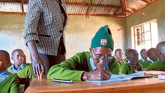 Priscilla Sitinei, de 90 años, escribe en su cuaderno durante una clase en la escuela de Ndalat (Kenia).