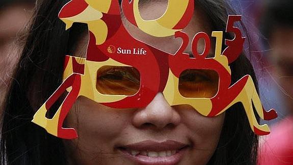 Una mujer posa con las gafas del Año Nuevo Chino de la Cabra en Manila, la capital de FIlipinas.