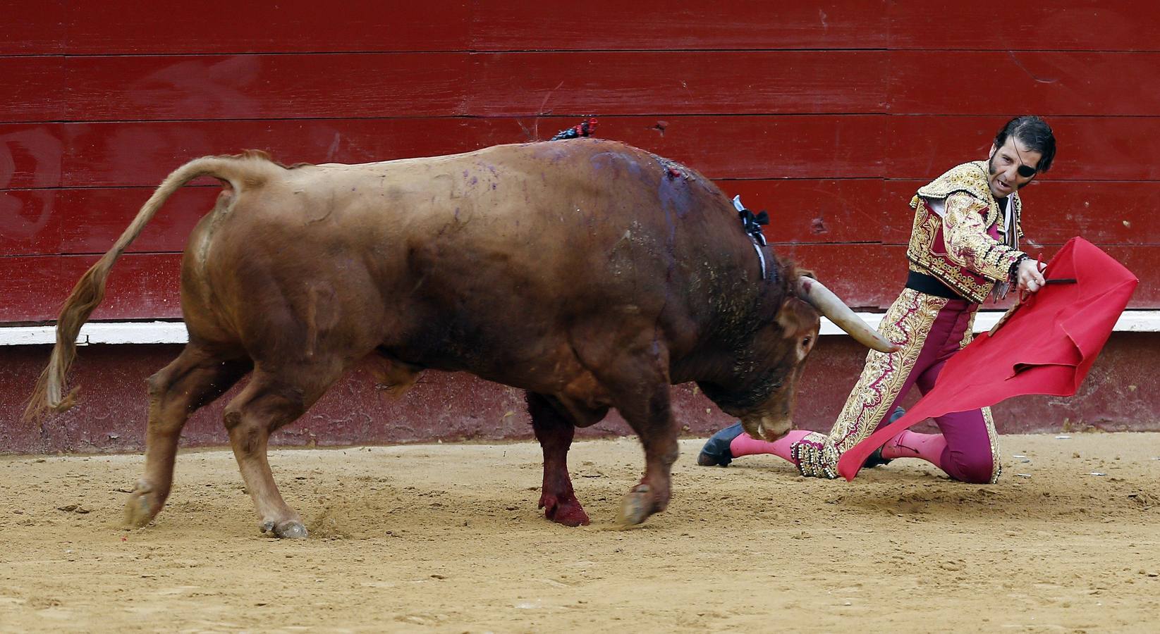 El diestro Juan José Padilla da un pase de rodillas a su primer astado en la quinta corrida de la Feria de Fallas.