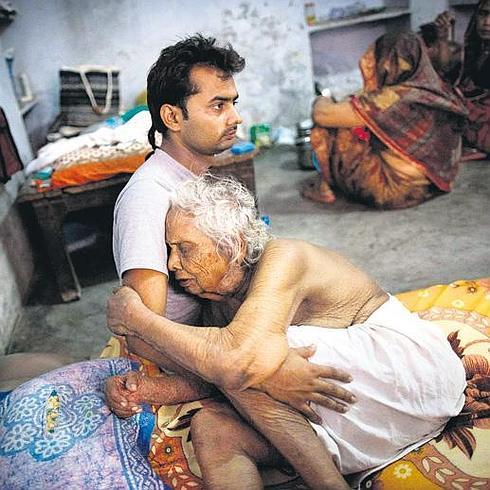 Divyesh Tiwari abraza a su abuela Bhogla Devi, de 97 años, en su habitación del Mukti Bhavan.
