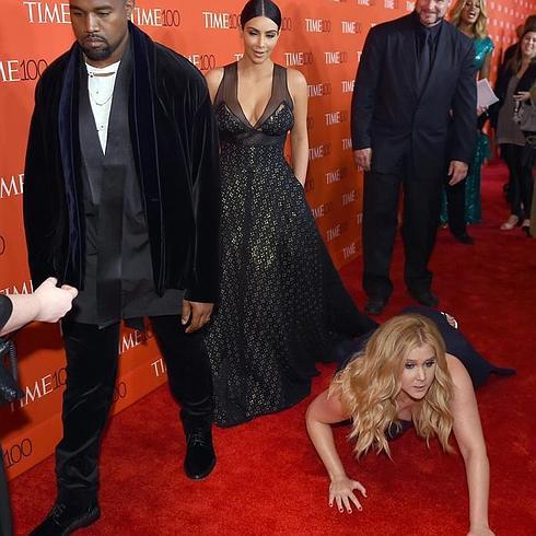 Kim Kardashian mira a Amy Schumer, después de caerse al suelo.