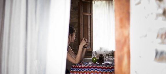 Una chica sentada junto a una ventana en La Calma, casa rural en Fuentes de Ayódar.:: lp