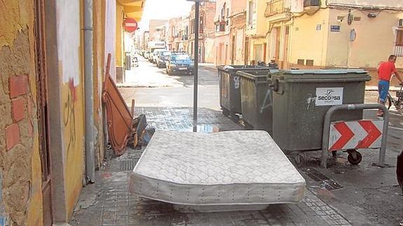Un colchón y restos de muebles abandonados en la calle Padre Luis Navarro, en el Cabanyal.