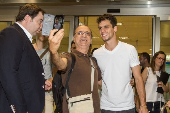 Rodrigo Caio posa con un aficionado en el aeropuerto de Manises. 