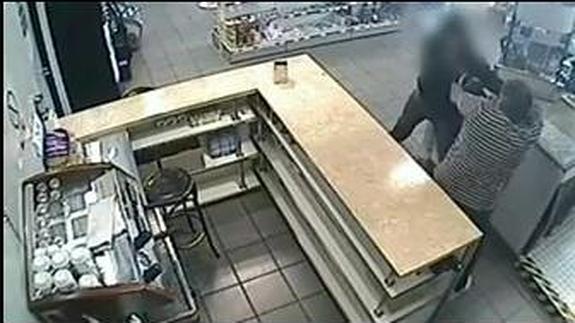 El atracador forcejea con el padre de la cajera de la estación de servicio.