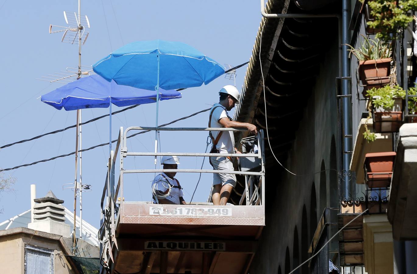 Trabajadores se protegen del sol hoy en Valencia.