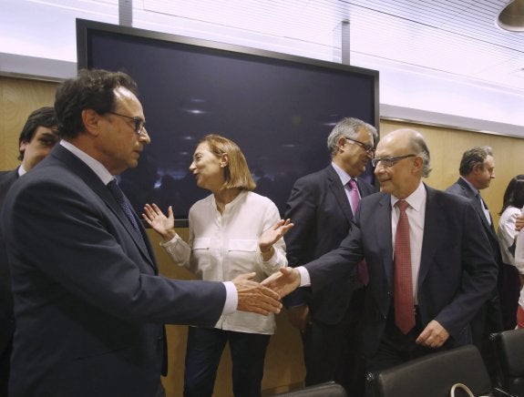 El conseller Vicent Soler saluda al ministro Montoro, ayer. :: EFE /Kiko Huesca