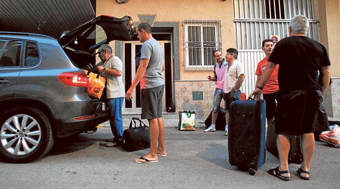 Emilio, el jefe de estos temporeros, carga uno de los coches junto a sus trabajadores.