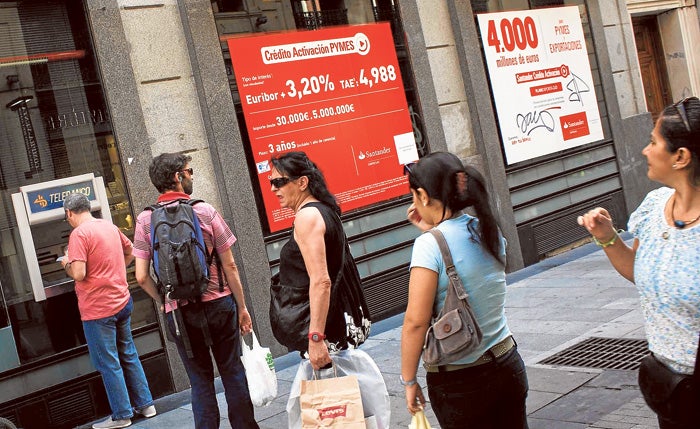 Clientes sacan dinero de un cajero automático en una sucursal del Santander en Madrid.