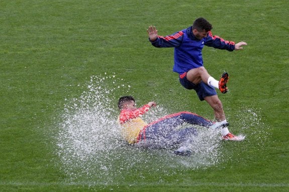 Gayà salta por encima de Cancelo en el entrenamiento que hizo el  equipo ayer en Paterna, en  medio de la fuerte tromba  de agua que cayó. :: j. signes 