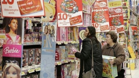 Dos mujeres observando la estantería de juguetes.