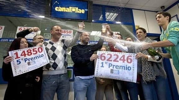 Vendedores de una administración de Lotería de Manises (Valencia) celebran haber vendido parte del primer y cuarto premios del sorteo de Navidad.