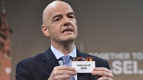 Gianni Infantino, secretario general de la UEFA, muestra el papel del sorteo con el nombre del Valencia. 