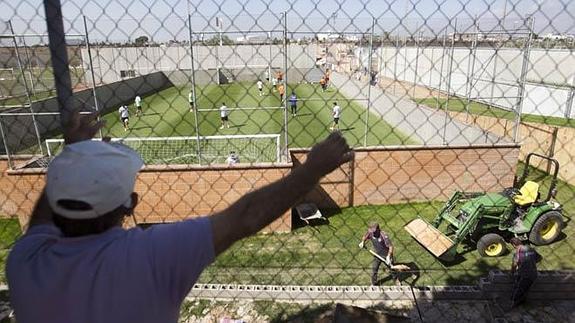 Un joven observa el entrenamiento del Valencia en la ciudad deportiva de Paterna.