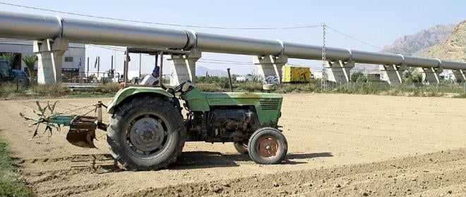 Un tractor en un terreno seco, junto a la tubería del trasvase Tajo-Segura, en el sur de Alicante.