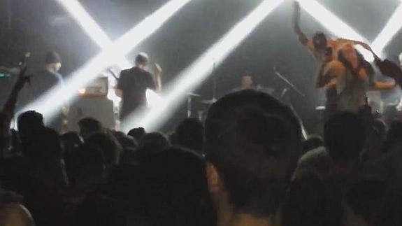 El cantante de un grupo punk tira del escenario a una fan de una patada