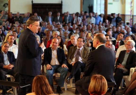 El presidente del Consell, Ximo Puig, durante su discurso de ayer en el Palau de l'Exposició de Valencia junto a Joan Calabuig. :: j.monzo