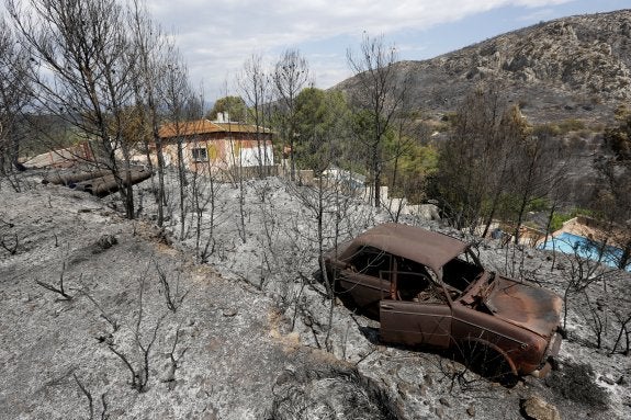 El fuego afectó a un vehículo y las parcelas de la urbanización Monte Campo de Carcaixent. :: jesús signes