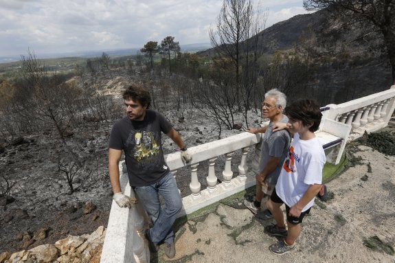 Vecinos observan los efectos del fuego desde su chalé. :: j. signes