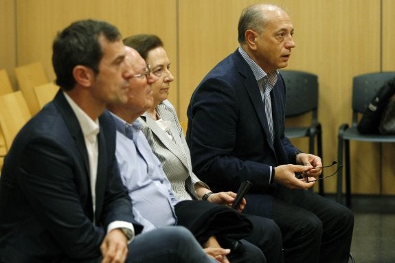 Carlos Crespo, sus padres, y al fondo Enrique Crespo, ayer, antes del inicio del juicio. :: irene marsilla