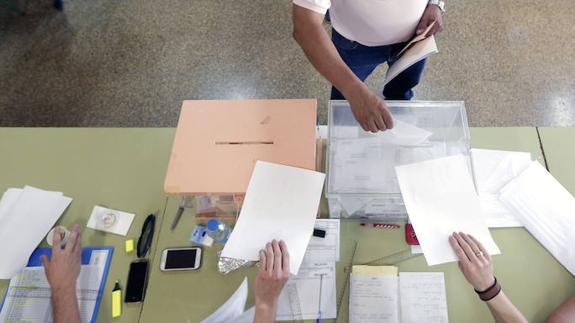 Un hombre deposita su voto en la urna del Congreso esta mañana en un colegio electoral.