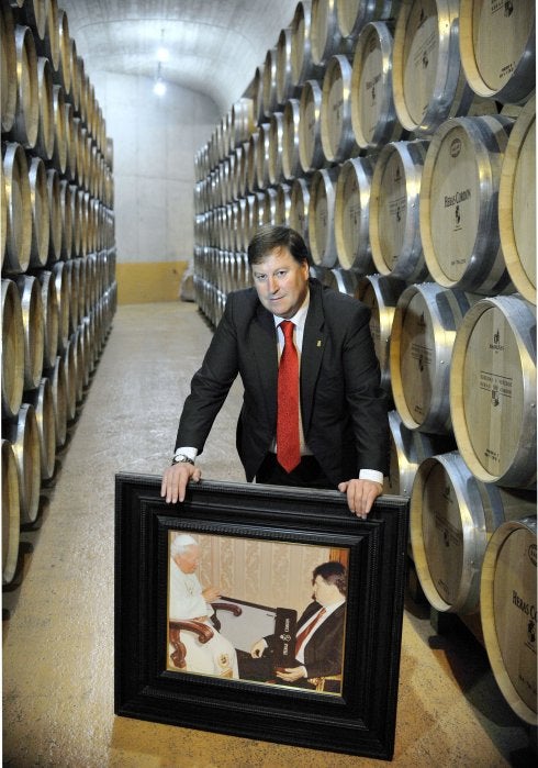 José Luis Heras Córdon, en su bodega de Fuenmayor, con una foto de la recepción que tuvo con Juan Pablo II.