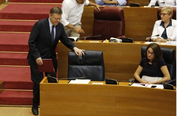 Ximo Puig toma asiento de su escaño, ayer en el pleno de Les Corts.