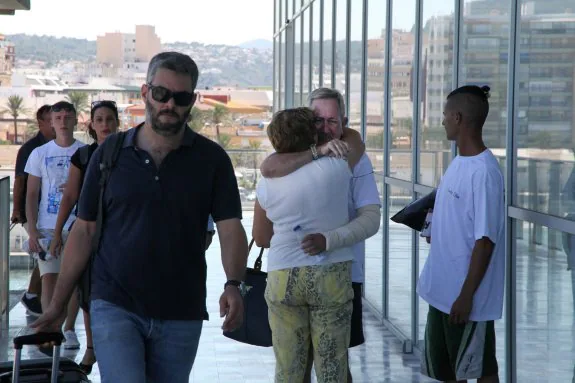 Ángel Garrigós, uno de los supervivientes del incendio de un barco en Ibiza, abraza a su mujer a su llegada a Dénia. :: tino calvo
