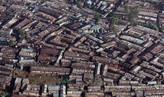 Vista aérea del mayor barrio de chabolas de África. En la imagen pequeña, una escolar huye de una de las frecuentes protestas que se producen en Kibera. 