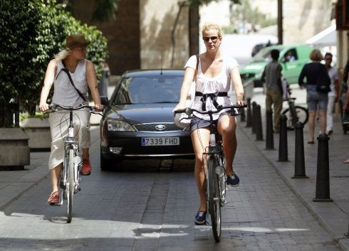 Un vehículo circula tras una bici en una calle peatonalizada. :: lp