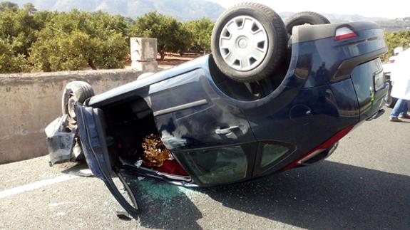 El coche volcado implicado en el accidente, en la CV-50 en Tavernes de la Valldigna.