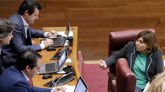 Bonig, hablando con sus compañeros del PP en el debate en Les Corts.