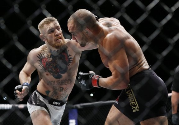 McGregor, izquierda,  con sus cinturones y,  arriba, en combate.  :: Usa Today