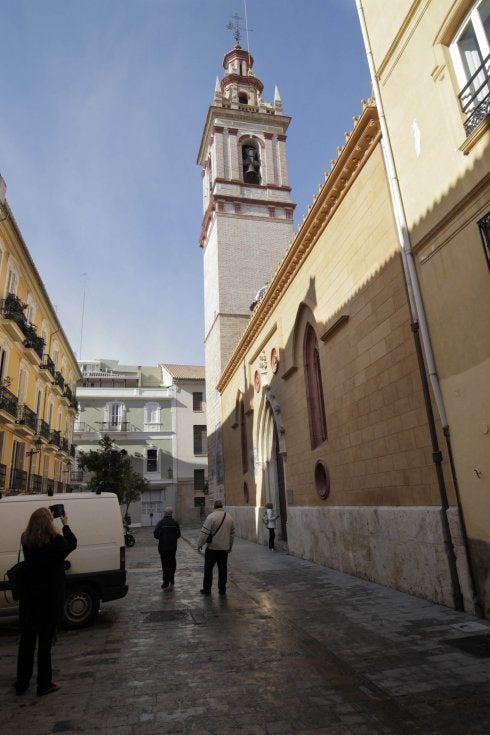 Un grupo de personas circulan frente a la iglesia de San Nicolás, cuyo campanario enmudeció ayer por orden del Ayuntamiento de Valencia. :: irene marsilla