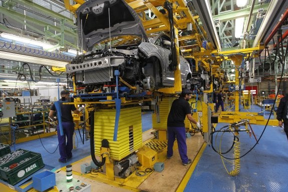 Trabajadores de Ford Almussafes en el proceso de montaje de un vehículo. :: juanjo monzó