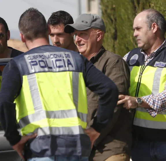 El presunto estafador Paco Sanz rodeado de policías el día de su detención en la Pobla de Vallbona. :: juanjo monzó