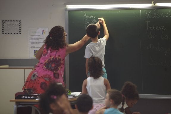 Una maestra ayuda a un alumno durante el primer día del curso. :: manuel molines