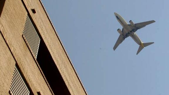 Un avión, volando sobre una zona de viviendas de Valencia, en una imagen de archivo.