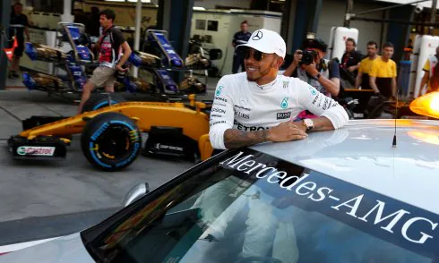 El piloto británico Lewis Hamilton, apoyado en un coche en el 'pit lane' de Melbourne. REUTERS