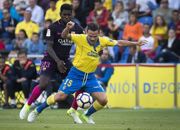 Umtiti comete falta sobre Roque Mesa. :: AFP PHOTO/JAIME REINA