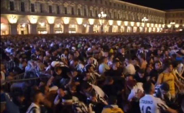 Un aficionado de la Juventus atiende a una mujer herida. 