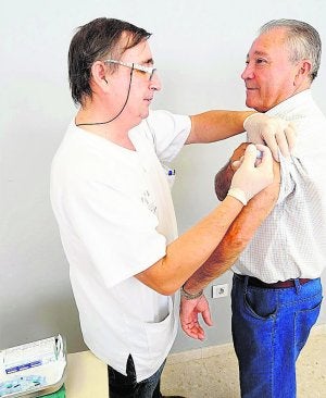 Un médico administrando una vacuna. ::
LP