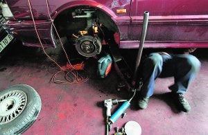 Un mecánico, rodeado de herramientas, repara un vehículo en un taller. /
LP