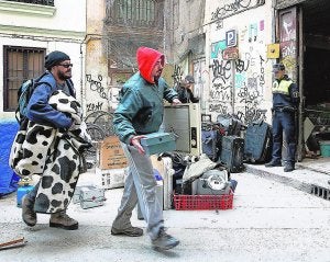 Algunos de los okupas abandonan el edificio mientras la policía controla el desalojo. ::                             TXEMA RODRÍGUEZ