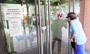 Una mujer, ayer por la tarde, comprueba que está cerrado un centro de salud de Valencia . ::                             JESÚS SIGNES