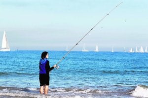 Una joven pesca en aguas de la playa de El Saler. ::                             JESÚS SIGNES