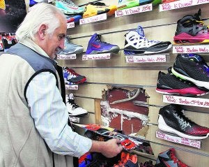 El propietario de la tienda muestra el agujero por el que entraron los delincuentes. ::                             IRENE MARSILLA