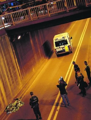 CAÍDA MORTAL. El cadáver del joven, tapado con una manta térmica, dentro del túnel. /TONI BLASCO